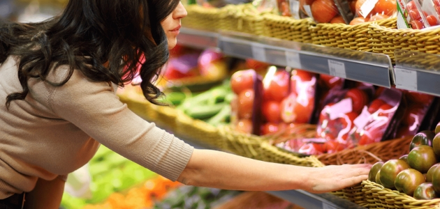 Assorted fruits and vegetables including strawberries, grapes, oranges, bell peppers, corn, and broccoli are arranged together, showcasing vibrant colors and fresh textures in a close-up view.