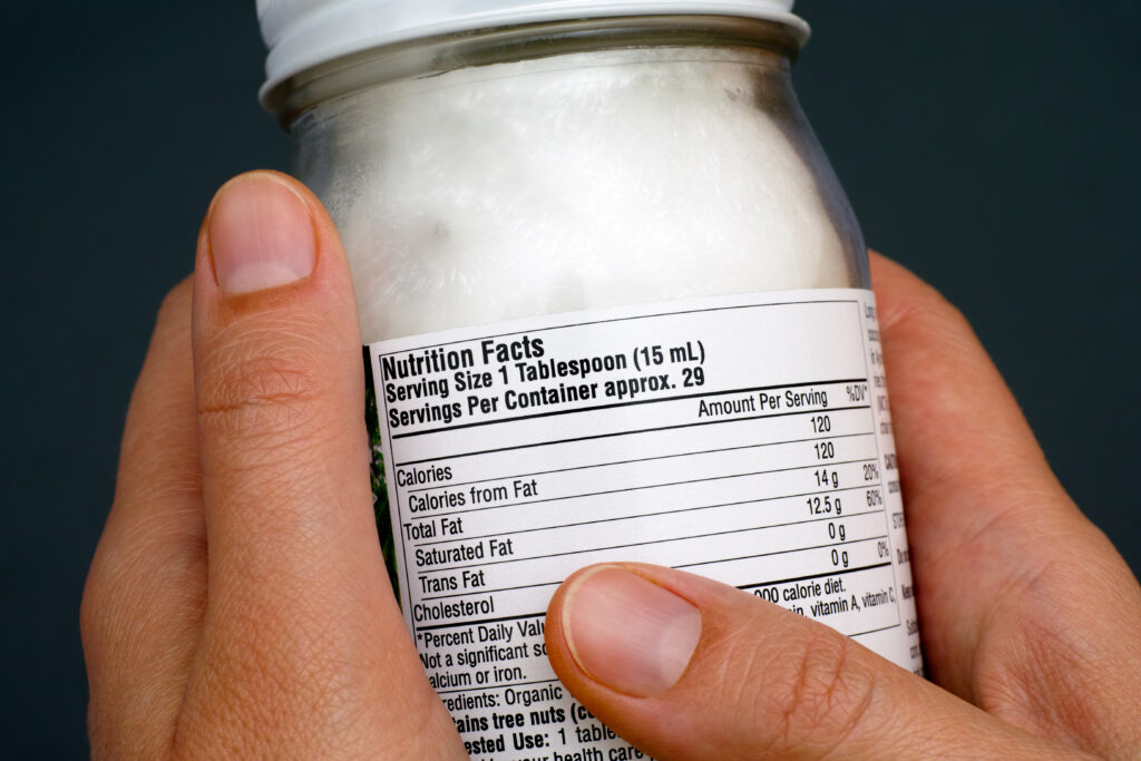 Reading a nutrition facts on organic coconut oil jar.