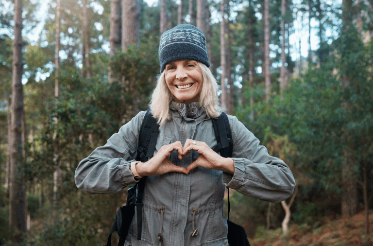 woman hiking with hands in shape of heart