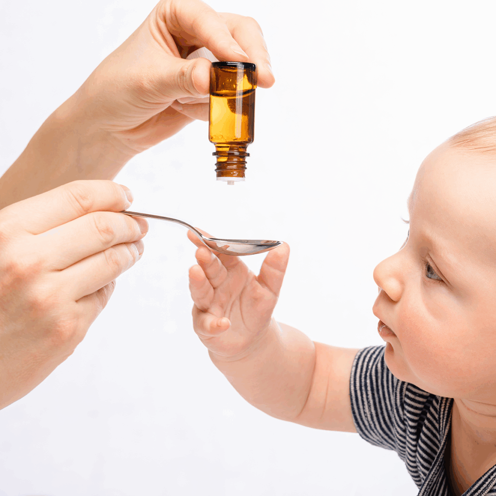 mother giving baby liquid vitamin d supplement