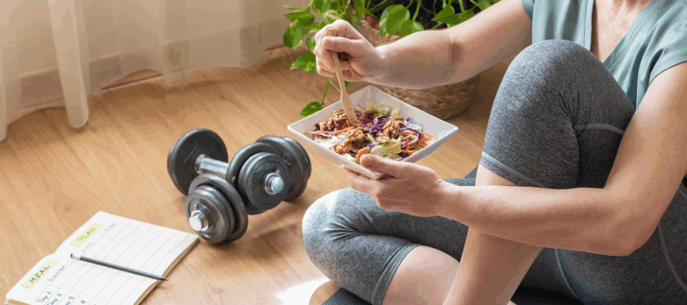 woman eating healthy salad after exercising