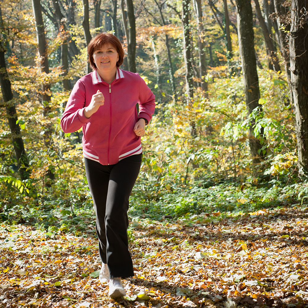 postmenopausal woman running in woods