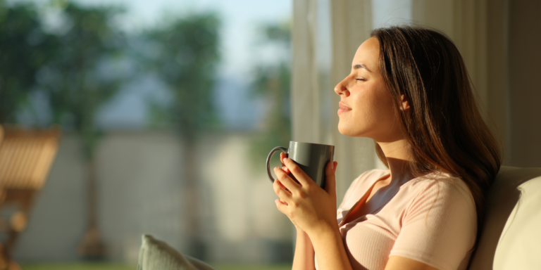 woman drinking tea and smiling with sun on face