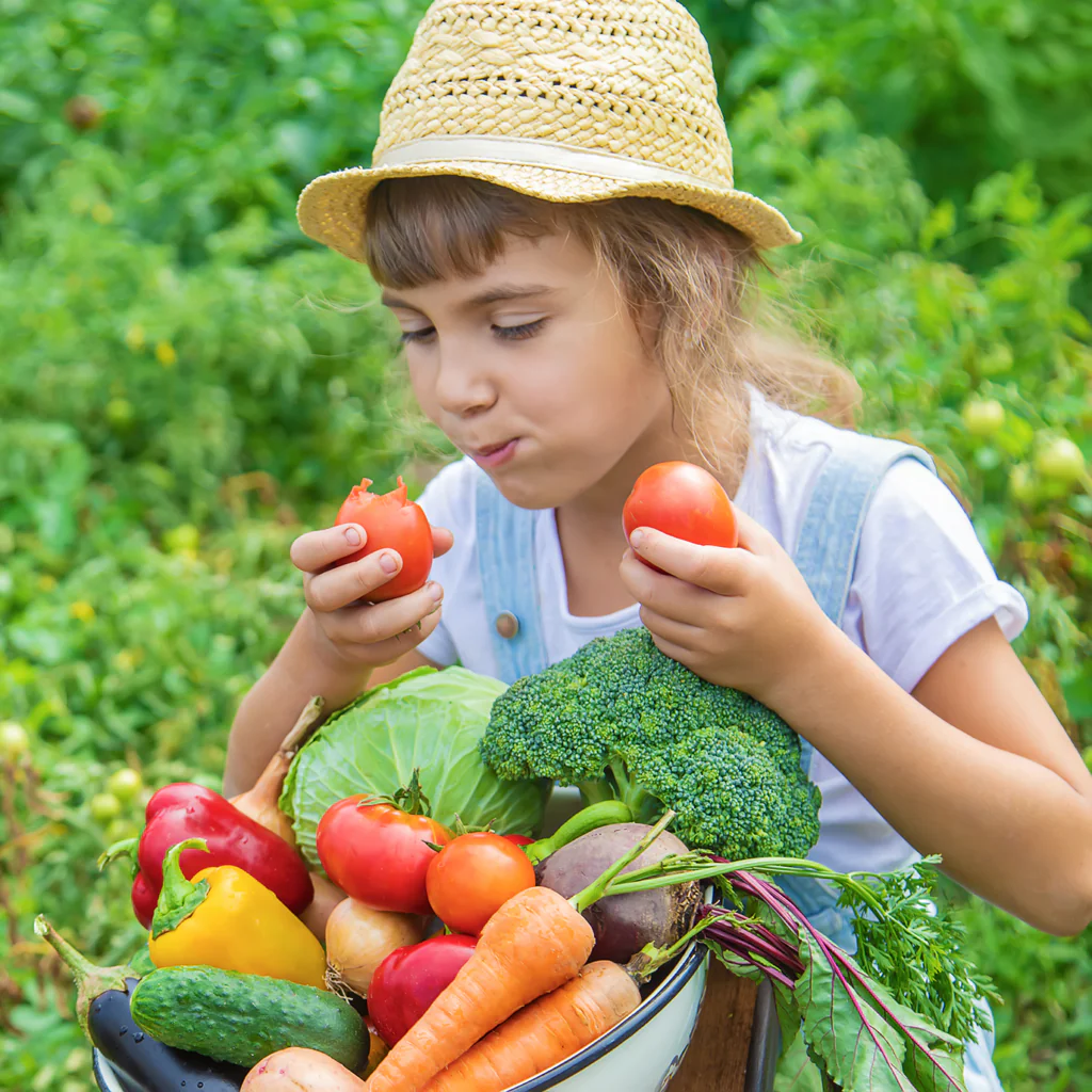 child eating vegetables in the garden